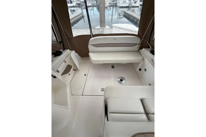 Slide: The Image of 2004 Regal Commodore 2765 boat interior with beige seating and marina view. - 6