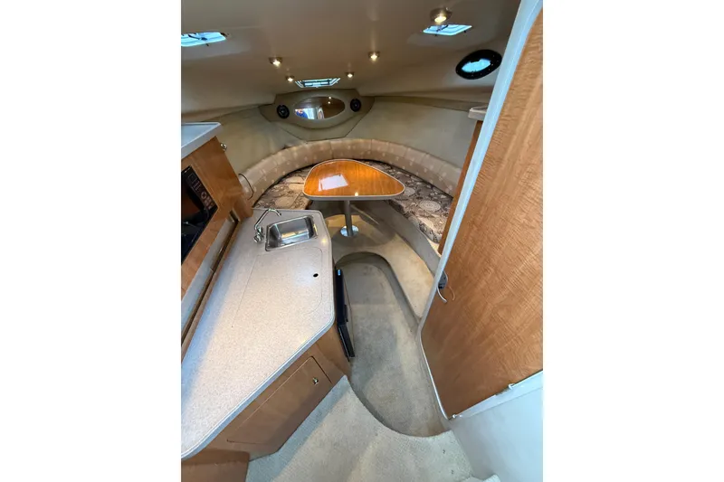 Slide: The Image of 2004 Regal Commodore 2765 cabin interior with kitchenette, seating, and wooden table. - 9