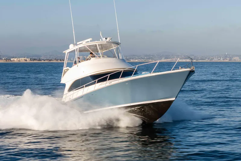 The Image of 2014 Viking 46 Convertible yacht cruising swiftly on open water. - 0