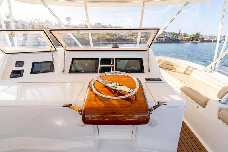 Slide: The Image of 2014 Viking 46 Convertible yacht helm with wooden steering wheel and navigation screens. - 15