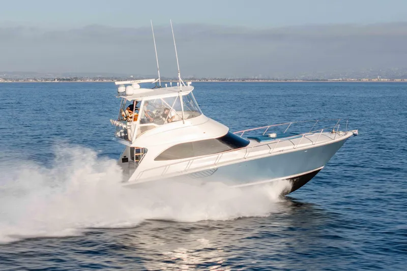 Slide: The Image of 2014 Viking 46 Convertible yacht cruising swiftly on open water. - 2
