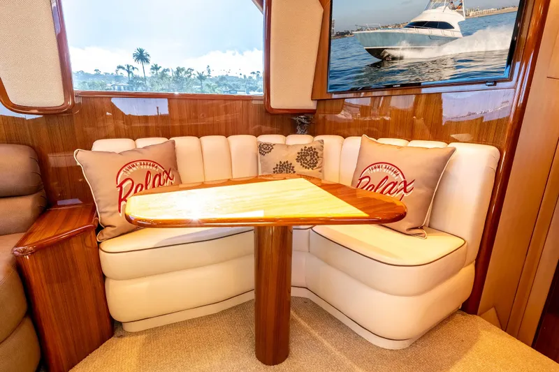 Slide: The Image of Cozy seating area in 2014 Viking 46 Convertible yacht with decorative pillows and wooden table. - 22