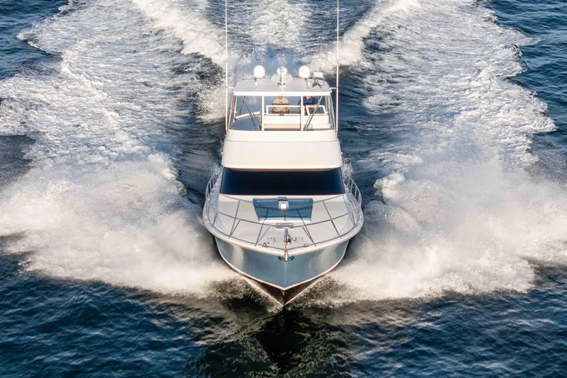 Slide: The Image of 2014 Viking 46 Convertible yacht cruising on open water, creating a dynamic wake. - 3