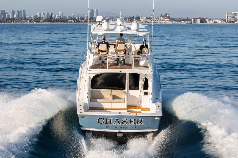 Slide: The Image of 2014 Viking 46 Convertible yacht cruising near city skyline, labeled "Chaser," Newport Beach, CA. - 4