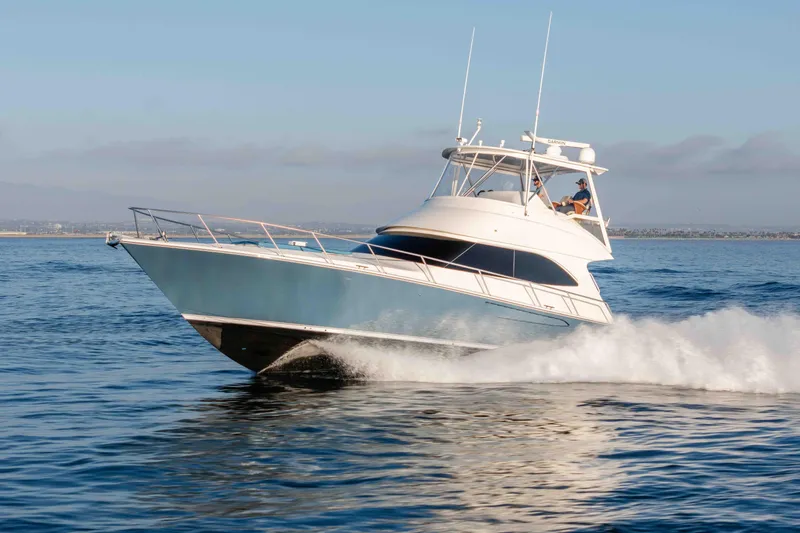 Slide: The Image of 2014 Viking 46 Convertible yacht cruising swiftly on open water. - 5