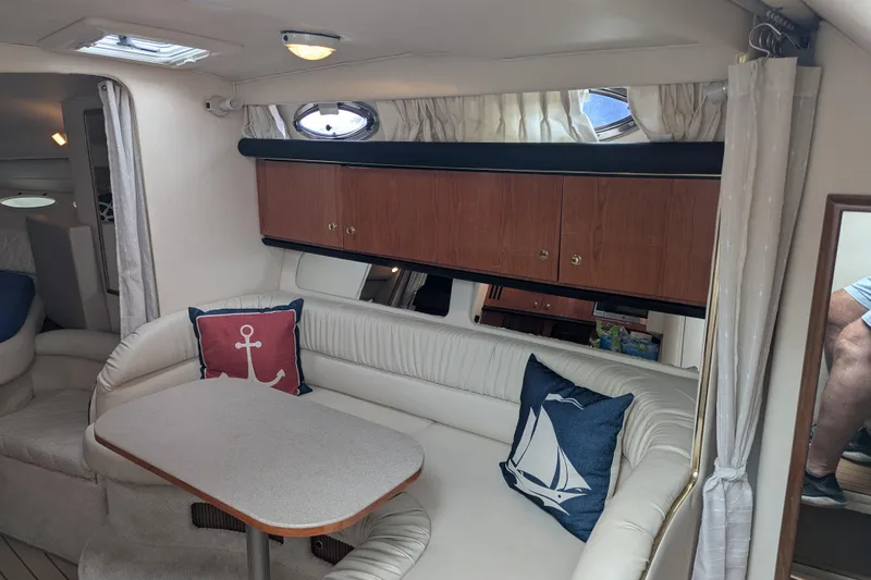 Slide: The Image of Interior of 2001 Sea Ray 340 Sundancer with cozy seating and nautical-themed pillows. - 10