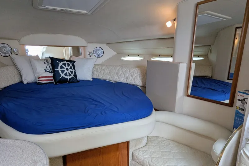 Slide: The Image of Interior of 2001 Sea Ray 340 Sundancer with blue bedding and nautical-themed pillows. - 11