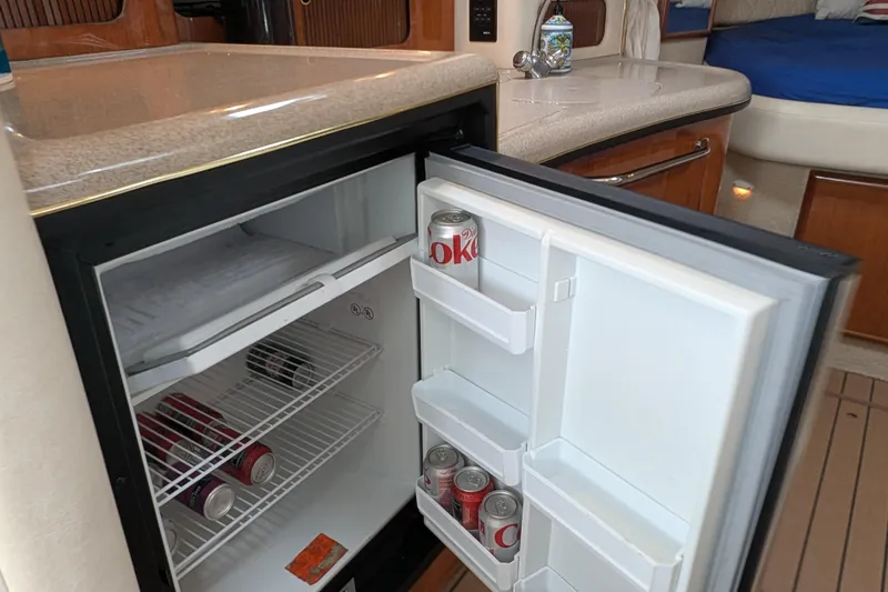 Slide: The Image of Mini fridge stocked with drinks inside a 2001 Sea Ray 340 Sundancer yacht cabin. - 15