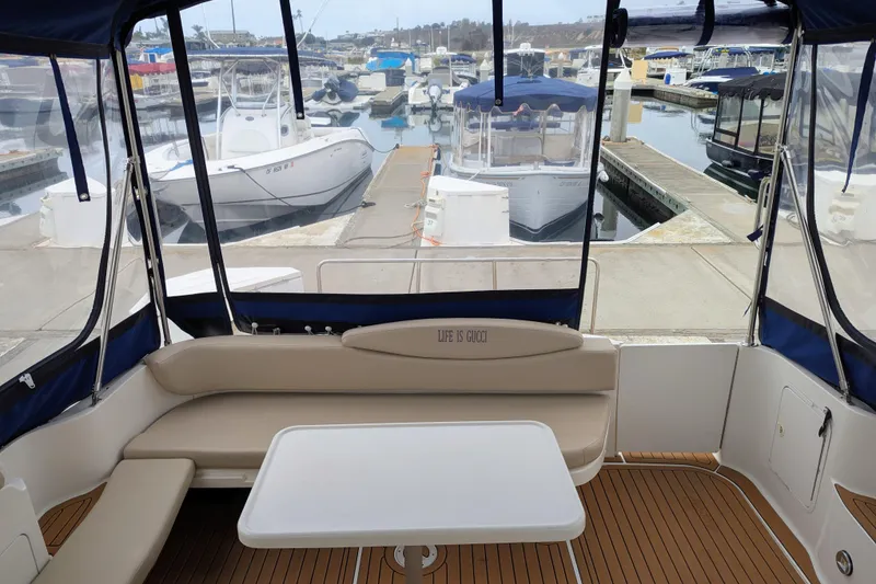 Slide: The Image of 2001 Sea Ray 340 Sundancer interior with seating and table at marina. - 2