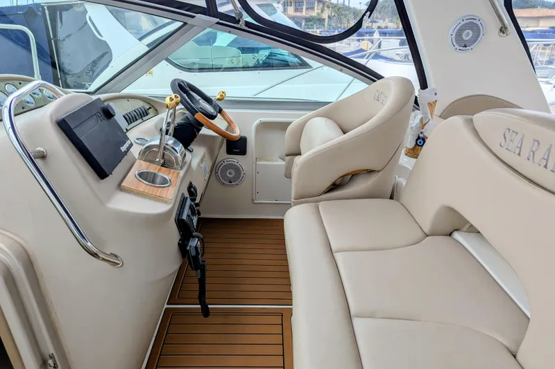 Slide: The Image of 2001 Sea Ray 340 Sundancer cockpit with beige seating and wooden accents. - 4