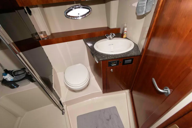 Slide: The Image of 2007 Cruisers Yachts 420 Express bathroom with sink, toilet, and wooden cabinetry. - 16