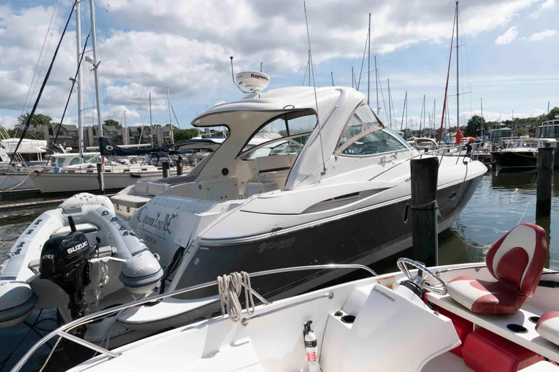 Slide: The Image of 2007 Cruisers Yachts 420 Express docked at marina with inflatable boat nearby. - 2