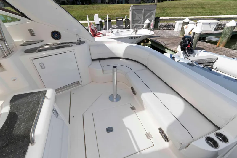 Slide: The Image of 2007 Cruisers Yachts 420 Express interior with white seating and kitchenette, docked at marina. - 4