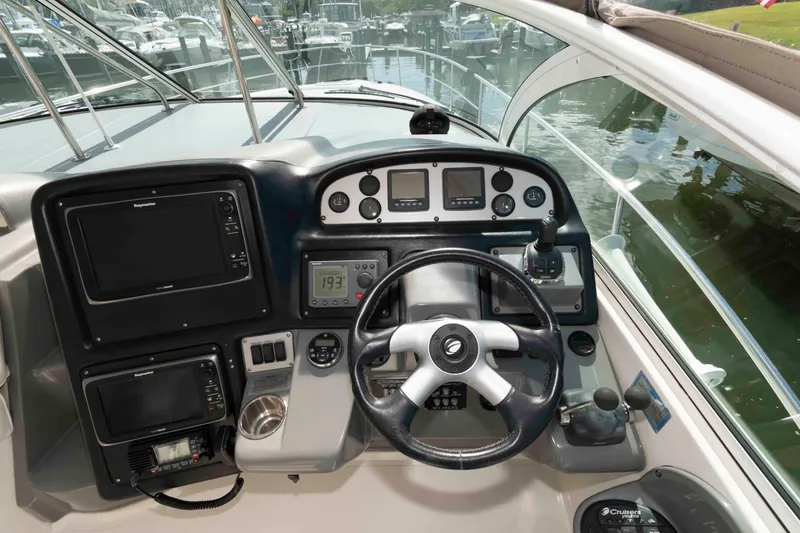 Slide: The Image of 2007 Cruisers Yachts 420 Express helm with navigation controls and steering wheel. - 7