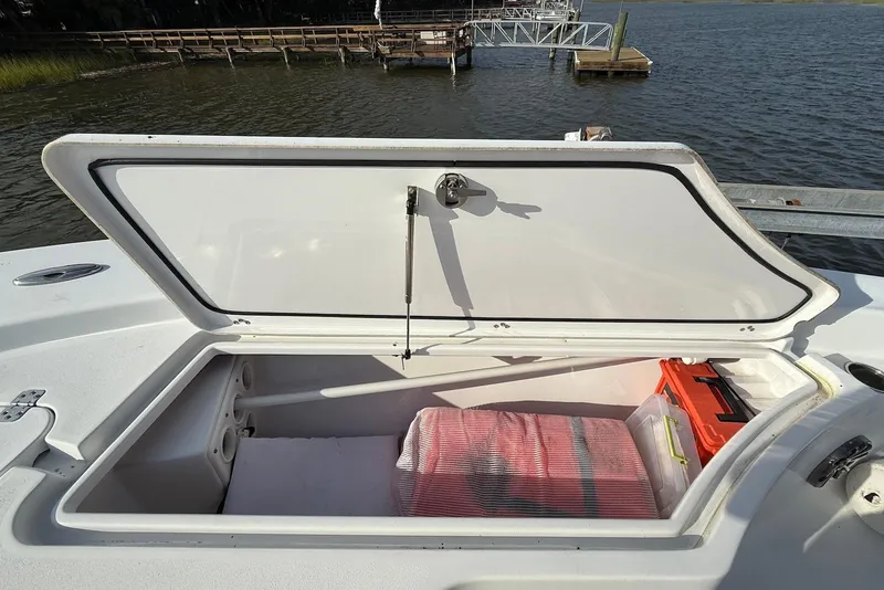 Slide: The Image of 2015 Sportsman Masters 247 Bay Boat storage compartment open by the water. - 11