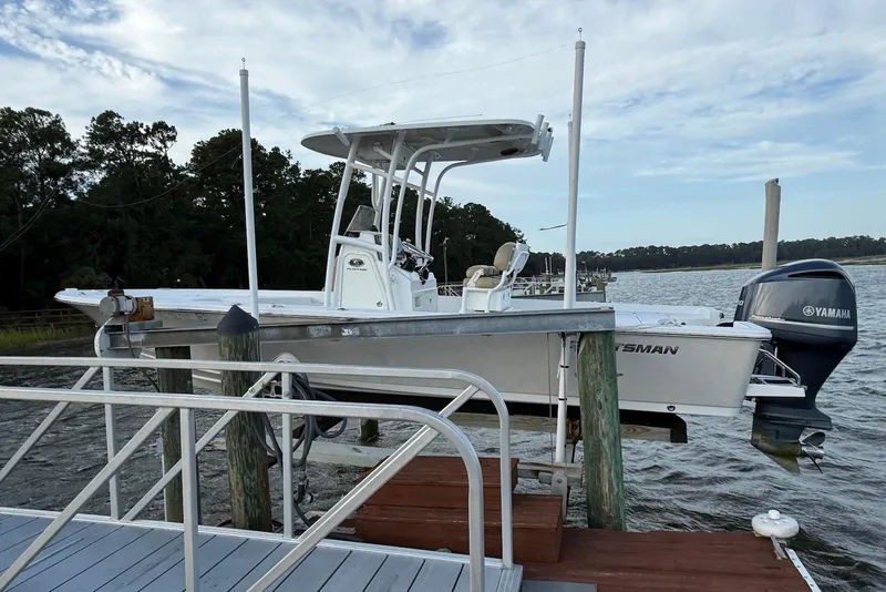 Slide: The Image of 2015 Sportsman Masters 247 Bay Boat docked with Yamaha engine, scenic waterfront. - 2