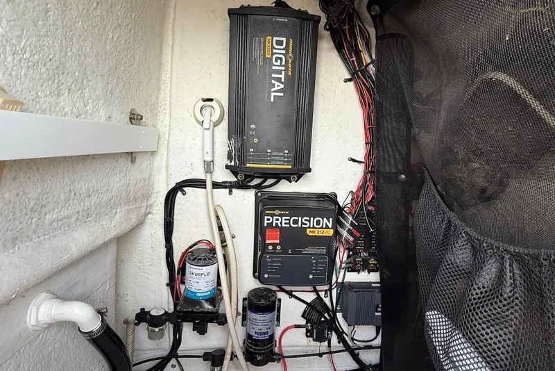 Slide: The Image of Electrical components inside a 2015 Sportsman Masters 247 Bay Boat, featuring wiring and chargers. - 22