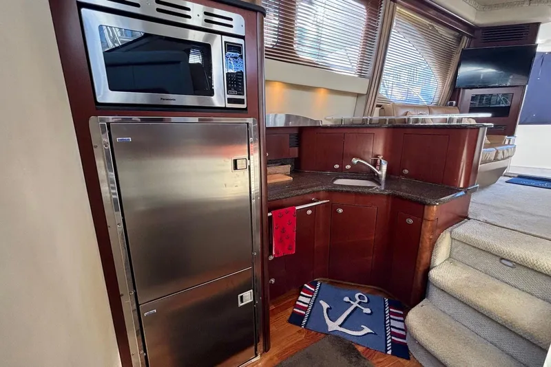 Slide: The Image of 2005 Sea Ray 420 Sedan Bridge docked, featuring blue canopy and "Well Worth It" name. - 13