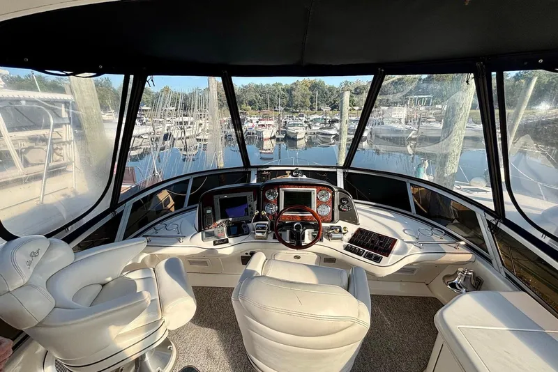 Slide: The Image of 2005 Sea Ray 420 Sedan Bridge yacht on water, side view, with marina background. - 4