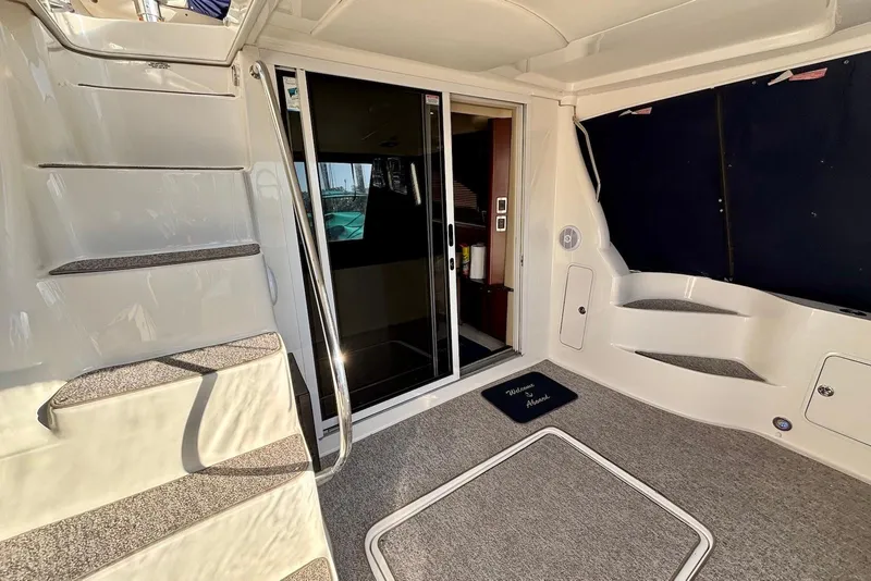 Slide: The Image of 2005 Sea Ray 420 Sedan Bridge interior with stairs, blue canopy, and marina view. - 7