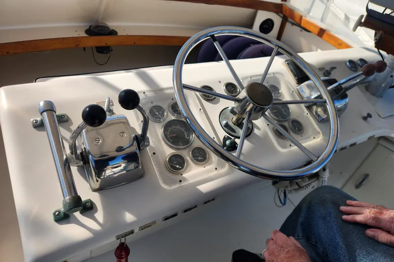 Slide: The Image of 1977 Post Sport Fish boat helm with steering wheel and control levers. - 13