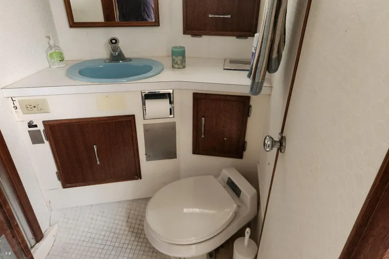 Slide: The Image of 1977 Post Sport Fish boat bathroom with blue sink, wooden cabinets, and toilet. - 18