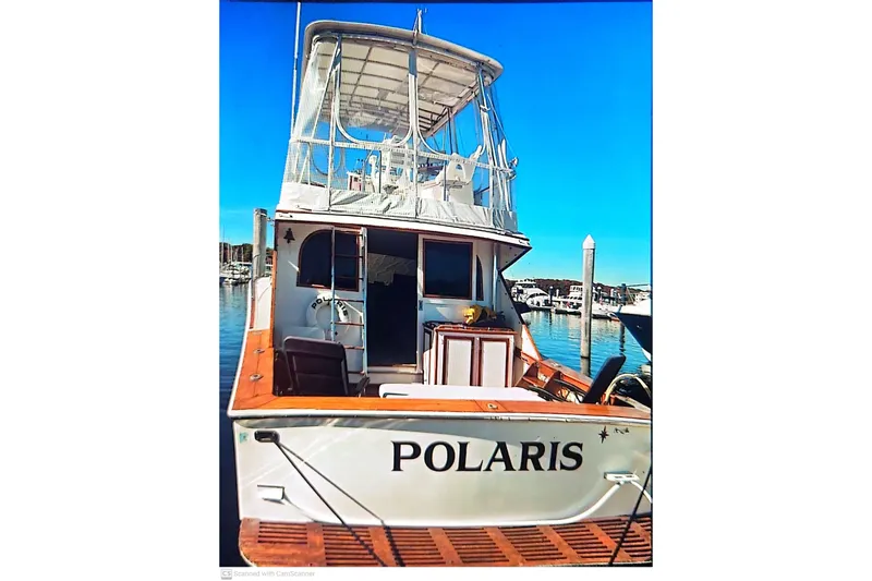 Slide: The Image of 1977 Post Sport Fish boat "Polaris" docked at marina under clear blue sky. - 2