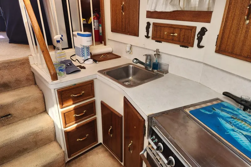 Slide: The Image of 1977 Post Sport Fish boat interior with kitchen sink, stove, and wooden cabinets. - 20