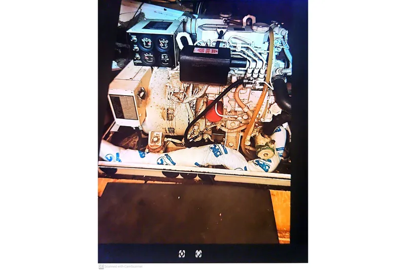 Slide: The Image of Engine compartment of a 1977 Post Sport Fish boat, showcasing mechanical components and wiring. - 23