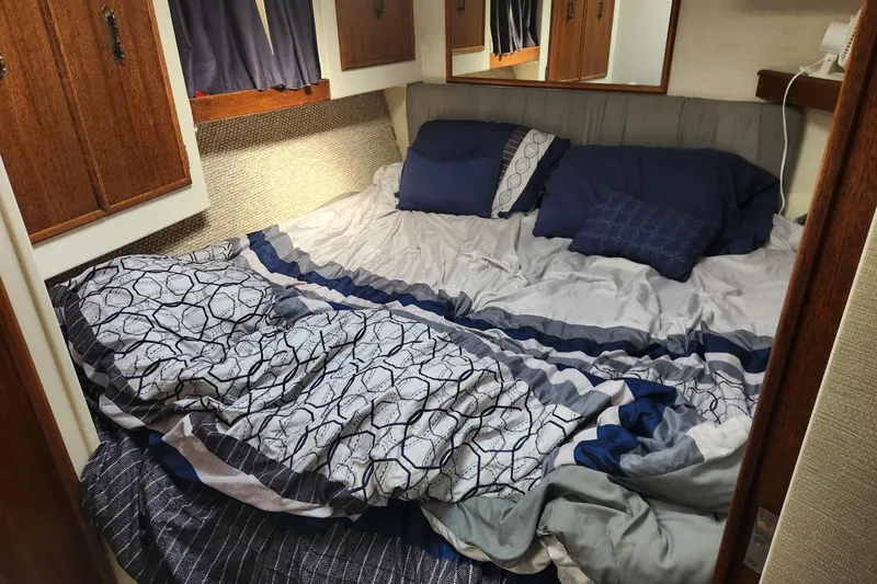 Slide: The Image of Cozy cabin bed in a 1977 Post Sport Fish boat with patterned bedding. - 9