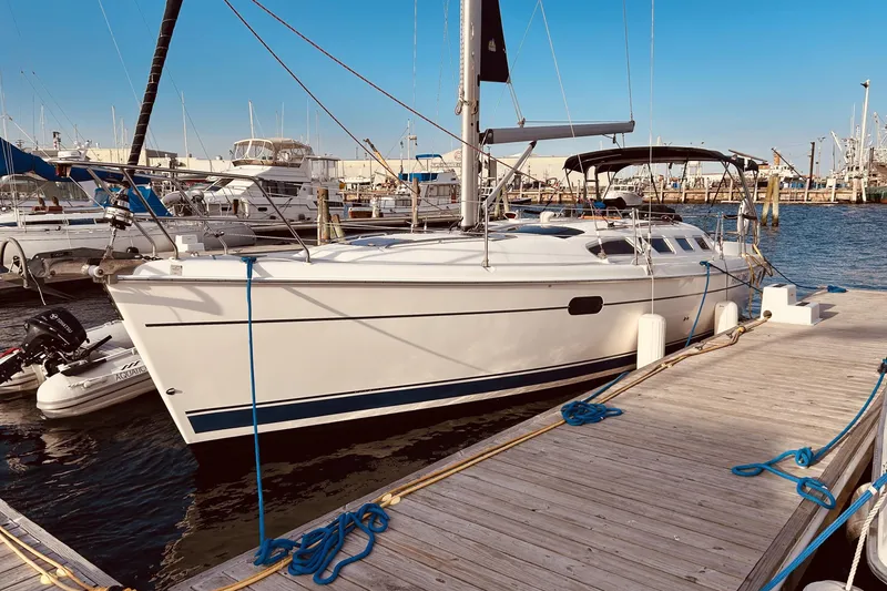 The Image of 2003 Hunter 386 sailboat docked at marina under clear blue sky. - 0
