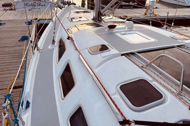 Slide: The Image of 2003 Hunter 386 sailboat docked, showcasing deck and cabin windows. - 11