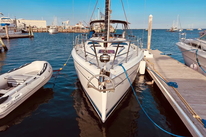 Slide: The Image of 2003 Hunter 386 sailboat docked at marina with inflatable dinghy nearby. - 12