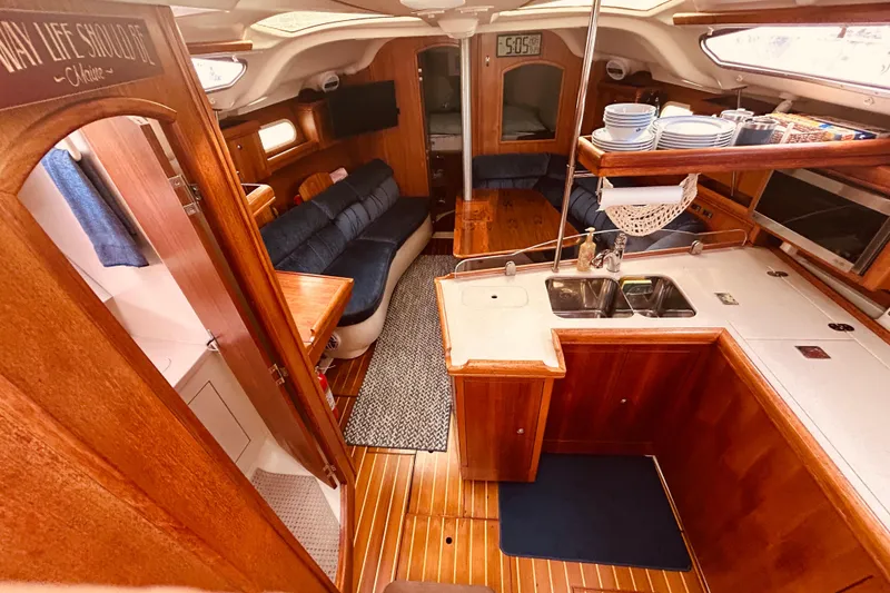 Slide: The Image of Interior of a 2003 Hunter 386 sailboat with wood finish and cozy seating area. - 13