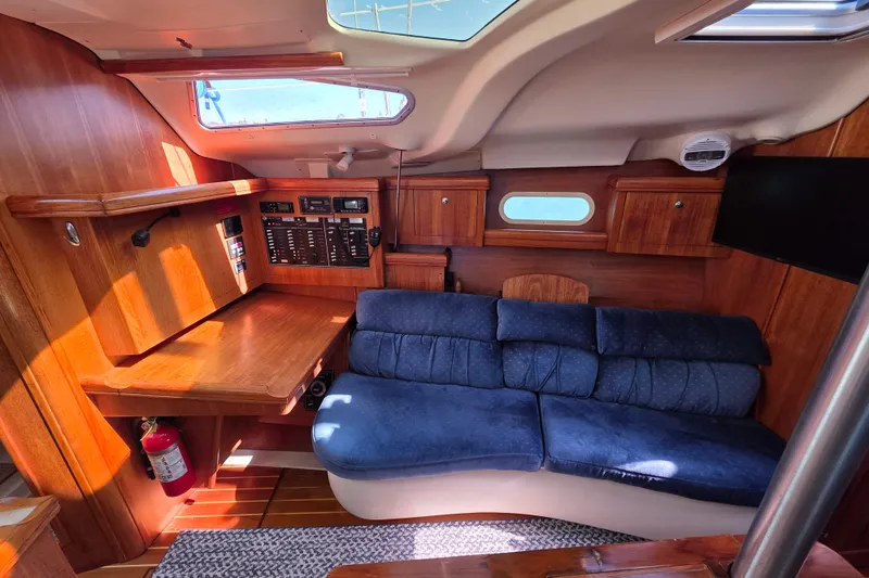 Slide: The Image of Interior of 2003 Hunter 386 sailboat with blue sofa and wooden cabinetry. - 17