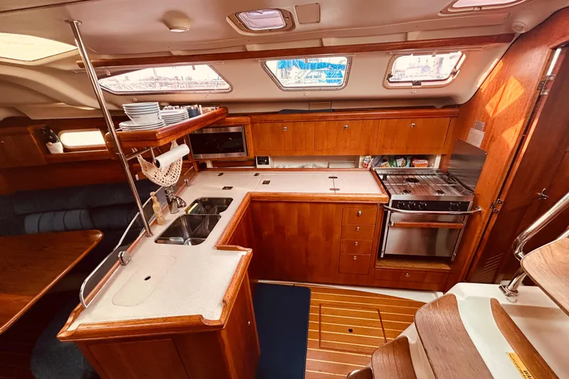 Slide: The Image of 2003 Hunter 386 yacht interior kitchen with wooden cabinetry and modern appliances. - 18