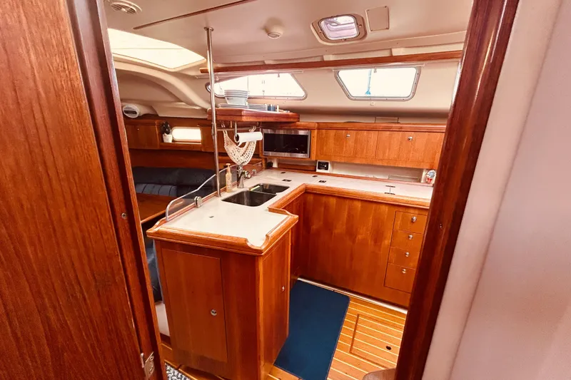 Slide: The Image of Interior of 2003 Hunter 386 sailboat with wooden cabinetry and modern kitchen amenities. - 19