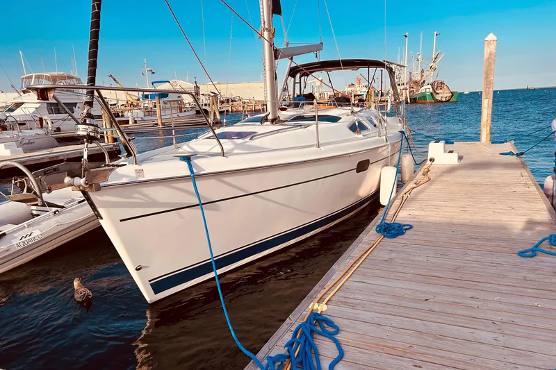 Slide: The Image of Hunter 386 sailboat from 2003 docked at a marina, with clear blue skies. - 2