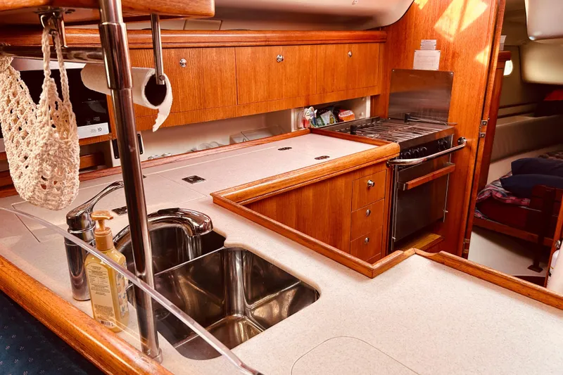 Slide: The Image of Luxurious 2003 Hunter 386 yacht kitchen with wood cabinetry and stainless steel sink. - 20