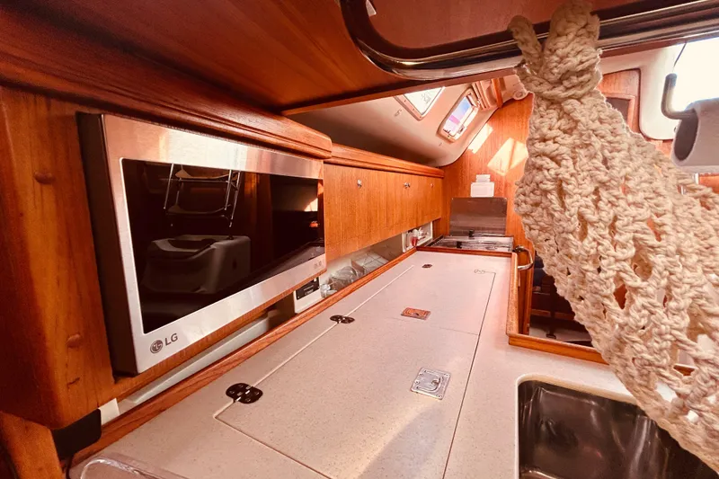 Slide: The Image of Interior of 2003 Hunter 386 sailboat kitchen with wooden cabinets and LG microwave. - 21