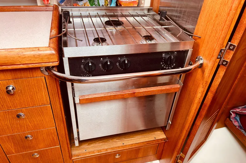 Slide: The Image of Stainless steel stove in a 2003 Hunter 386 yacht kitchen, surrounded by wooden cabinetry. - 22