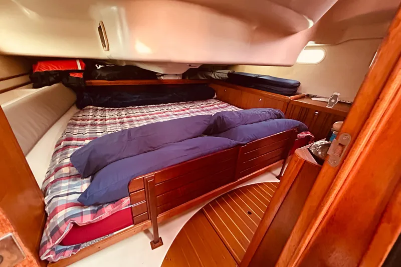 Slide: The Image of Cozy cabin interior of 2003 Hunter 386 sailboat with plaid bedding and wooden furnishings. - 23