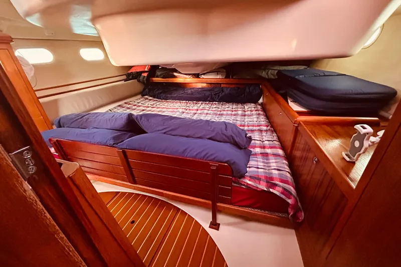 Slide: The Image of Cozy cabin interior of 2003 Hunter 386 sailboat with plaid bedding and wooden furnishings. - 24
