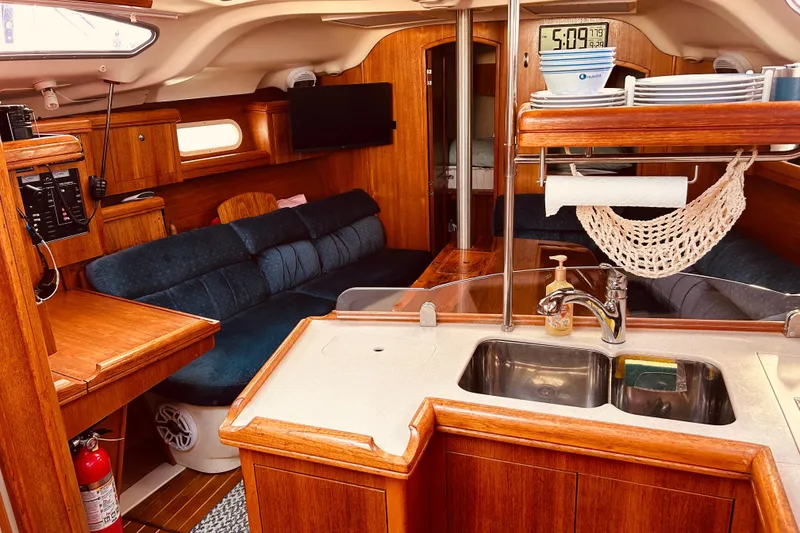 Slide: The Image of Interior of a 2003 Hunter 386 sailboat with wooden cabinetry and cozy seating area. - 26
