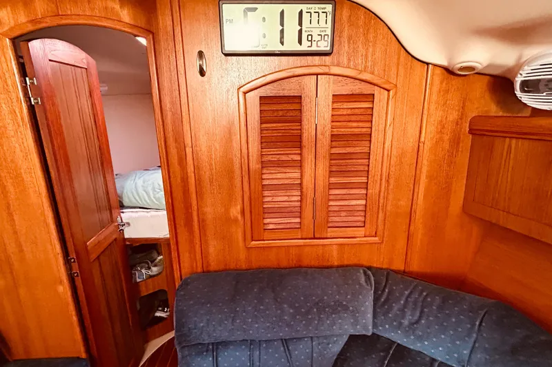 Slide: The Image of Interior of 2003 Hunter 386 sailboat with wooden paneling and digital clock. - 28