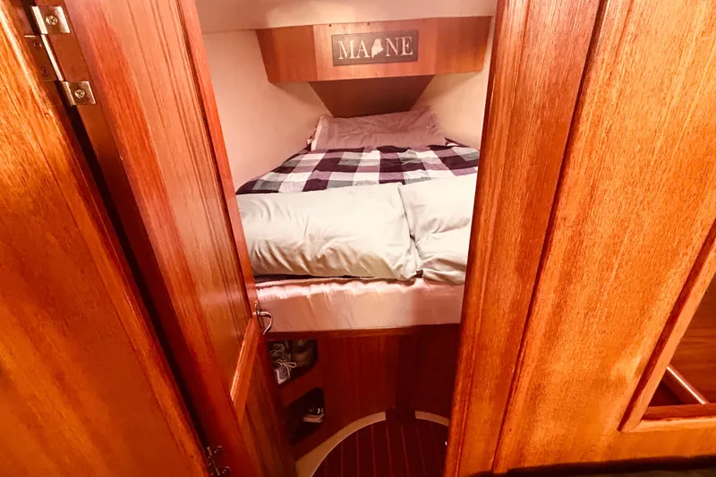 Slide: The Image of Cozy cabin interior of 2003 Hunter 386 sailboat with wooden finish and comfortable bedding. - 29