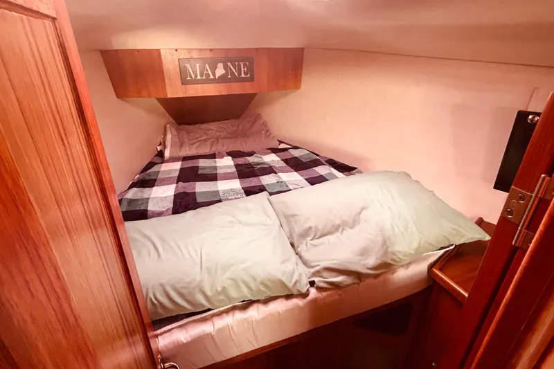 Slide: The Image of Cozy cabin bedroom in 2003 Hunter 386 sailboat with plaid bedding and "Maine" sign. - 30