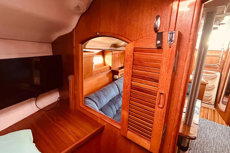 Slide: The Image of Interior of 2003 Hunter 386 sailboat with wooden cabinetry and blue seating. - 32