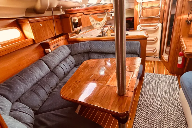 Slide: The Image of Cozy interior of 2003 Hunter 386 sailboat with wooden furnishings and blue seating. - 34