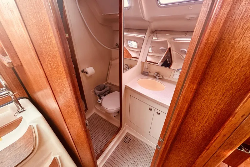 Slide: The Image of Interior of 2003 Hunter 386 sailboat bathroom with wooden finish and compact design. - 37